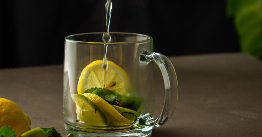 A morning scene with a glass of warm lemon water, denoting the integration of this beneficial drink into a daily routine.